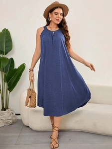 Close-up of a blue sleeveless A-line beach dress with textured fabric and crew neckline