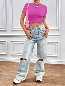 Détail du haut court rose avec découpe en cœur et jean large à jambes déchirées