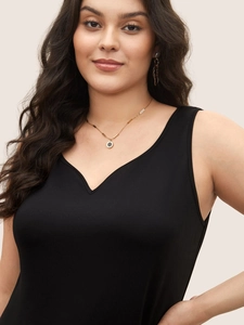 Women's black V-neck sleeveless rib knit top paired with elegant golden jewelry accessories