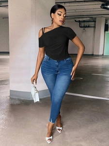 Women black off-shoulder ribbed knit top with skinny blue jeans and white accessories