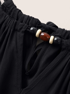 Nahaufnahme des V-Ausschnitts mit elastischen Falten, Cut-out und bunten Zierperlen