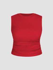 Detail of red sleeveless tank top featuring a ruched waist and classic round neck