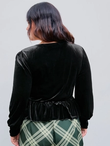 Elegant black velvet V-neck long sleeve top with peplum hem shown on a model side view