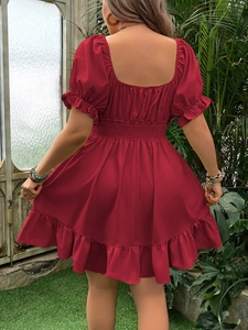 Détail de robe rouge à manches bouffantes montrant le dos et l'ourlet à volants