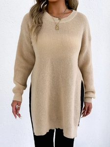 Detail of beige knit sweater showing high side slits and vertical ribbed texture