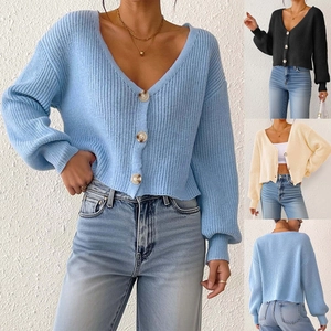 Détail du cardigan en maille avec boutons texturés marbre et poignets côtelés bleus