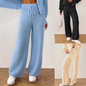 Detail view of knitted wide-leg trousers with drawstring waist in blue, black and beige