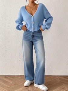 Détail d'un cardigan en maille bleu clair avec de gros boutons et une texture douce