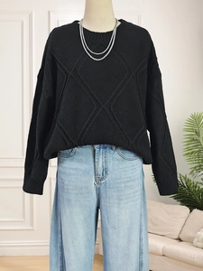 Close-up of black diamond knit sweater texture and detailed diamond weave pattern