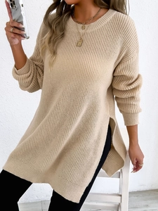 Detail shot of beige oversized knit sweater featuring round neck and side slit hem design