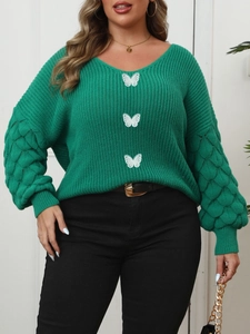 Close-up of green V-neck sweater with white lace butterfly appliques and puff bubble sleeves