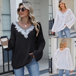 Detail showing the elegant white lace embroidery on the V-neckline of a knit sweater