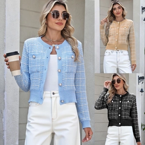 Close-up of knit plaid cardigan featuring pearl buttons and decorative front pockets