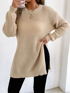 Detailed close-up of side slit and ribbed knit texture on beige oversized sweater