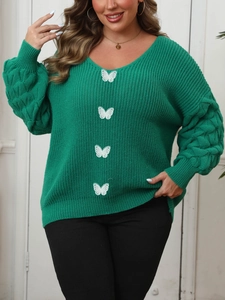 Detail of green V-neck sweater with white butterfly embroidery and textured puff sleeves
