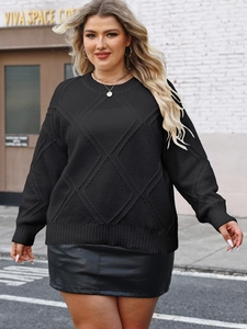 Close-up of black oversized knit sweater featuring a detailed diamond texture and ribbed cuffs
