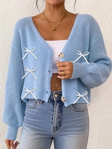 Détail d'un cardigan en maille côtelée bleu clair avec col en V et boutons en corne