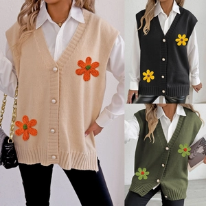 Détail du gilet en tricot avec fleurs au crochet 3D et boutons en perles multicolores
