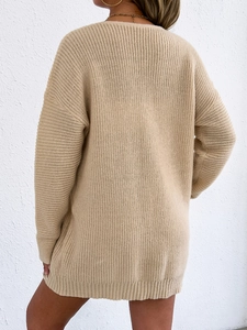 Back view of oversized deep V-neck knit sweater dress in beige with ribbed cuffs