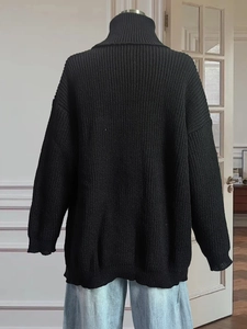 Oversized black turtleneck knit sweater with vertical ribbing and side slit design