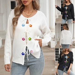 Dettaglio di fiori colorati all'uncinetto su cardigan in maglia con chiusura a fiocco
