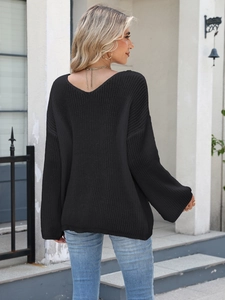 Rear view of an oversized black V-neck knitted sweater with loose fit texture