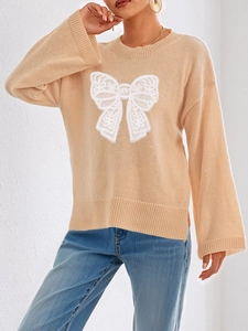 Apricot knit sweater with white lace bow applique and flared sleeves on white background