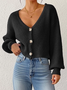 Gros plan du cardigan noir en maille côtelée avec des boutons marron en écaille