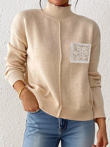 Detail of crochet floral patch on beige mock neck sweater with rib-knit cuffs