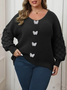 Close-up of black V-neck knit sweater featuring white butterfly patches and texture sleeves