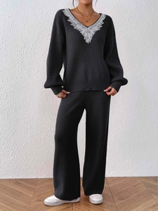 Detail of V-neck knit sweater with white feather embroidery and wide-leg trousers