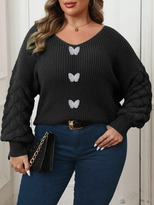 Detail of black V-neck knit sweater featuring white butterfly embroidery and lantern sleeves