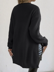 Detail view of the black knit sweater back featuring a side split and ribbed texture