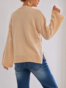 Detail of apricot crewneck knit sweater with ribbed cuffs and side slit hem design