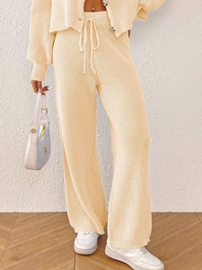 Detail of drawstring elastic waistband on beige knitted wide-leg trousers for women