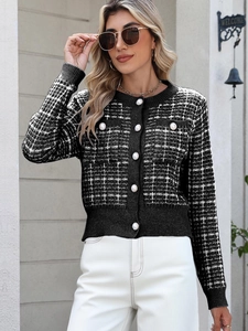 Detail of elegant black and white tweed knit cardigan with decorative pearl buttons