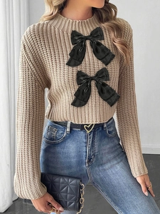Women's beige knit crop sweater with black bow details and stylish flare sleeves