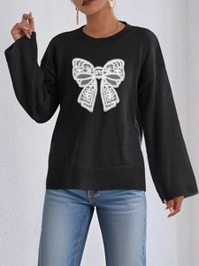 Close-up of black long sleeve knit sweater featuring a white lace bow detail