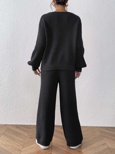 Black knit two-piece set featuring V-neck sweater and wide-leg pants in a back view pose