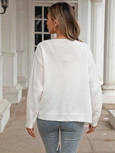 Back view of a white knitted cardigan with bow tie details and ribbed cuffs