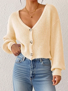 Gros plan du gilet en maille crème avec boutons marbrés et texture en maille côtelée