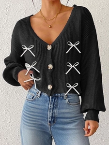 Gilet en maille noire avec col en V profond, boutons en bois et nœuds blancs sur le devant
