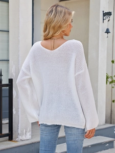 Detail of white chunky knit sweater featuring V-back neckline and loose casual fit