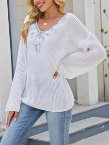 Detail of sequin embroidery and feather lace trim on the white V-neck knitted sweater