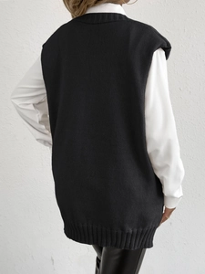 Women's black knit vest with pearl buttons layered over white shirt back view
