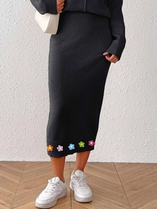 Detailed view of colorful knit flower accents on black knitted bodycon pencil skirt