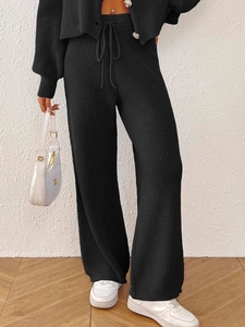 Detailed close-up of black knitted two-piece set featuring vertical ribbed texture and drawstring