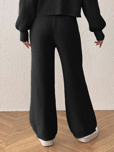 Detail view of black knit wide leg pants showing soft ribbed texture and back fit draping