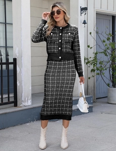 Close-up of elegant black and white plaid knit suit featuring pearl buttons and tweed texture