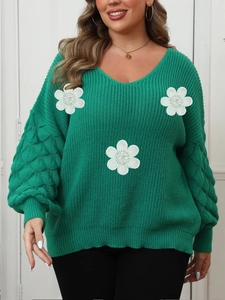 Detail of green V-neck knit sweater featuring 3D white floral appliques and puff sleeves